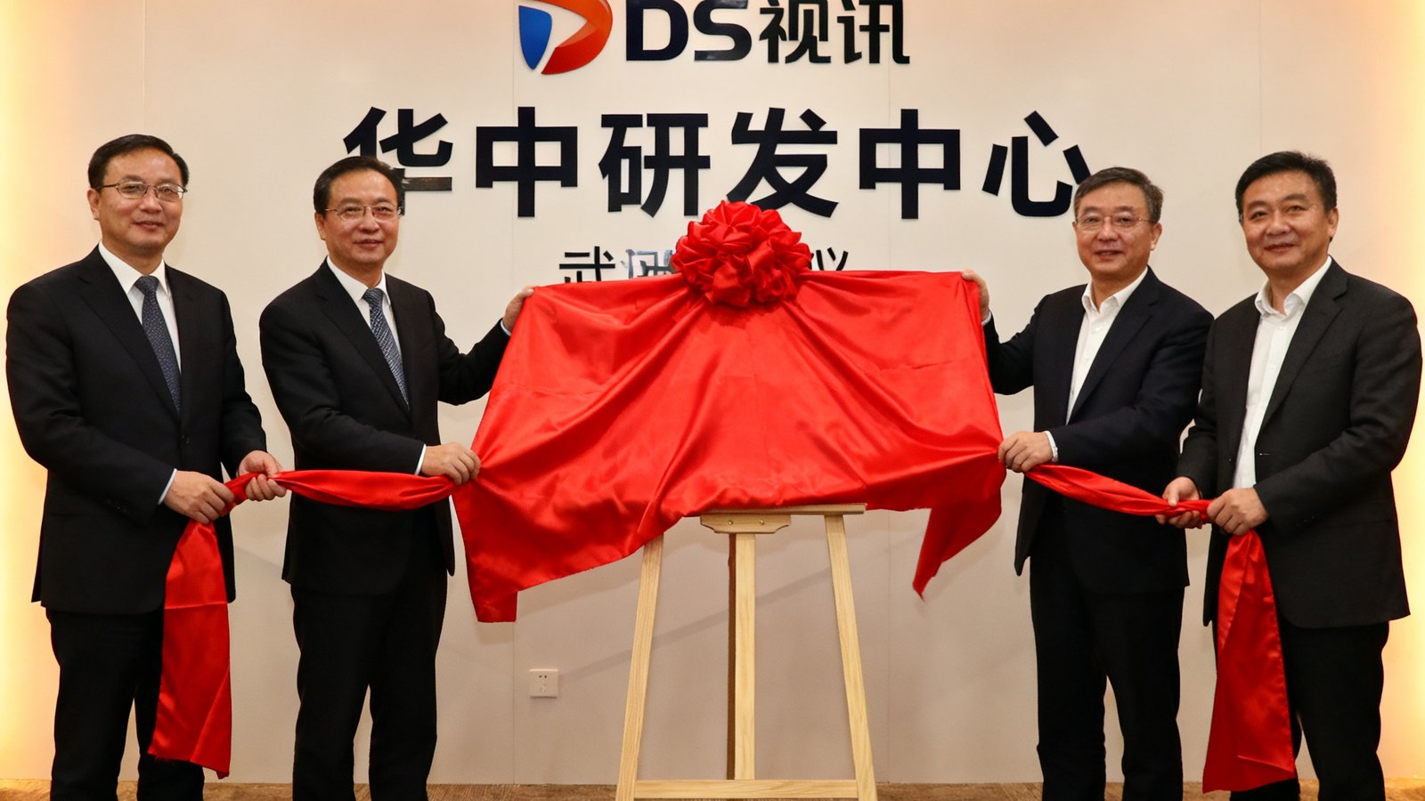 DS视讯武汉研发中心揭牌仪式现场，公司高层与武汉当地政府领导共同揭开红绸，背景板上印有DS视讯Logo和'华中研发中心'字样。